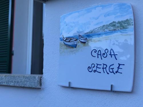 a sign on the side of a building with two boats at Casa SERGE vista mare con ampio terrazzo privato in Bergeggi