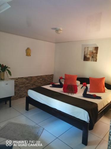 a bedroom with a bed with orange and black pillows at Hotel Belvedere Playa Samara Costa Rica in Sámara
