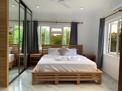 sypialnia z łóżkiem i dużym lustrem w obiekcie CAM Getaway Villa w mieście Praslin