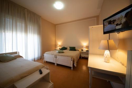 a bedroom with two beds and a flat screen tv at Hotel Venezuela in Montesano sulla Marcellana