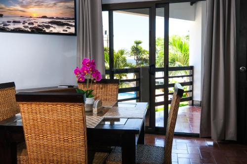 a dining room with a table and chairs and a balcony at Hotel Terraza del Pacifico in Jacó