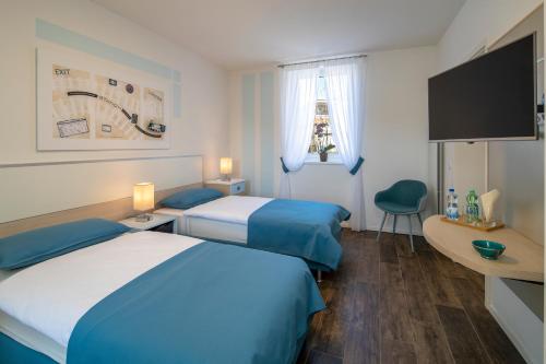 Cette chambre comprend 2 lits et une télévision à écran plat. dans l'établissement Albergo Ristorante Stazione Balerna, à Balerna