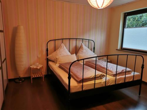 ein Schlafzimmer mit einem Bett mit weißen Kissen und einem Fenster in der Unterkunft Holiday Home Scheuerberg in Oberthal
