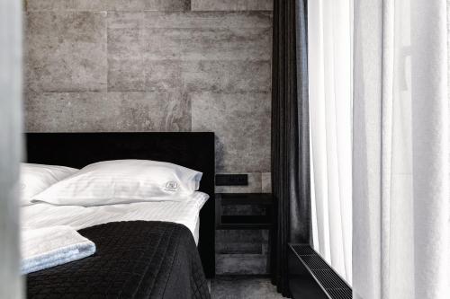 a bedroom with a bed with white pillows next to a window at PLATiNIUM RESIDENCE&SPA BASEN-SAUNA "BEST VIEW" CENTER in Lublin