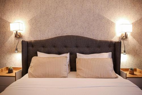 a bedroom with a large bed with two pillows at City Apartment Cipariu in Cluj-Napoca
