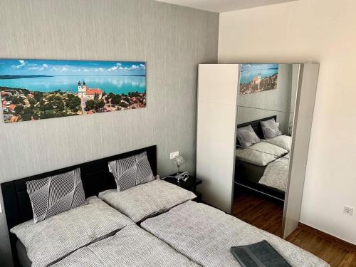 a bedroom with two beds and a large mirror at Amulett Wellness Apartman in Siófok