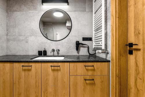 a bathroom with a sink and a mirror at PLATiNIUM RESIDENCE&SPA BASEN-SAUNA "BEST VIEW" CENTER in Lublin