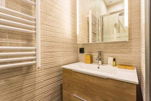 a bathroom with a sink and a mirror at HSH Alexandre Dumas Lovely Apartment 2BR-6P in Paris