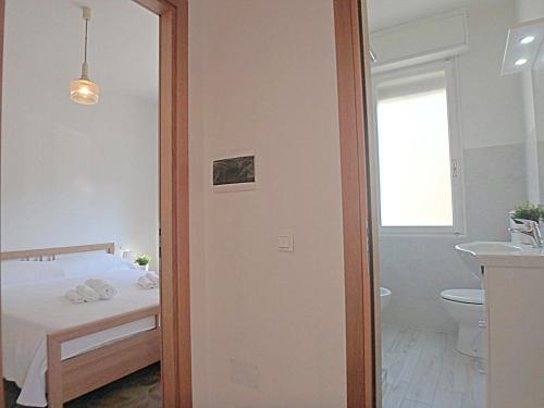 sypialnia z łóżkiem oraz łazienka z umywalką w obiekcie Pasubio 1 w mieście Lido di Pomposa