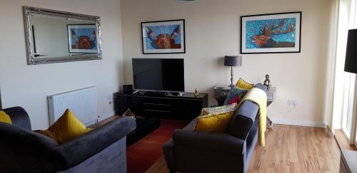 a living room filled with furniture and a tv at Aberfeldy Lodge Guest House in Inverness