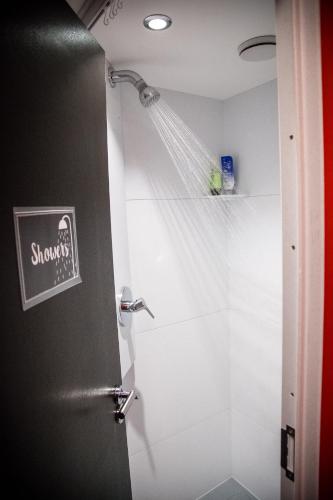 a bathroom with a shower with a shower at Balmers Hostel in Interlaken