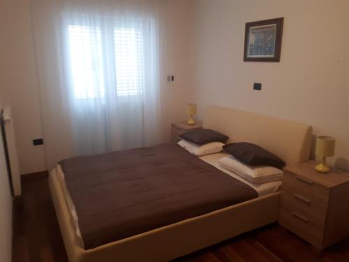 a bedroom with a large bed and a window at Pleasing place in Fažana