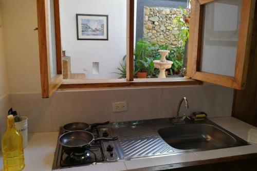 a kitchen counter with a sink and a window at Parrot House San Antonio in Cali