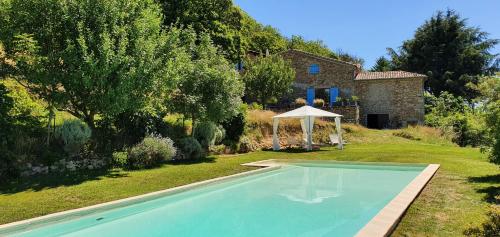 une piscine dans une cour avec une maison dans l'établissement La Grange - Chez Gisi - für Naturliebhaber, Abenteurer und Geniesser, à Rocles