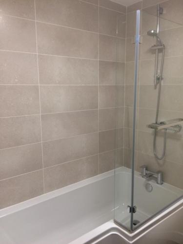 a shower with a glass door in a bathroom at Hilltop Cottage in Dursley