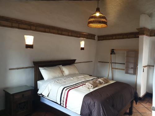 a bedroom with a bed with a stuffed animal on it at Casona Real Santa Barbara in Ráquira