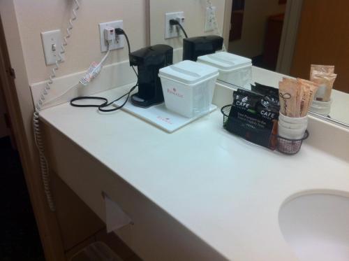 a bathroom counter with a sink and a toilet at Ramada by Wyndham SeaTac Airport in SeaTac