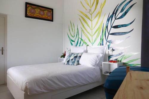 Un dormitorio con una cama con un mural en la pared. en Villa 5* avec piscine et vue mer exceptionnelle, en Fort-de-France