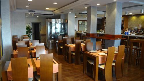 restauracja z drewnianymi stołami i krzesłami oraz bar w obiekcie Hotel El Volao w mieście Villanueva de Córdoba