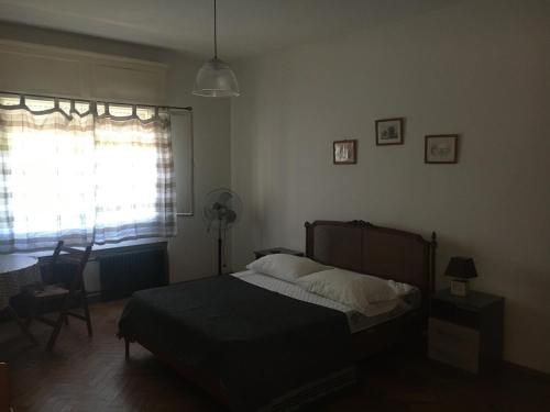 a bedroom with a bed and a desk and a window at Petit in Fray Bentos