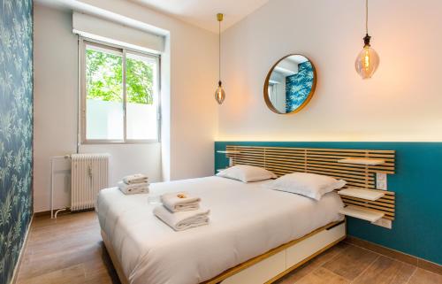 ein Schlafzimmer mit einem großen Bett und einem Spiegel in der Unterkunft CMG Nation - Charonne D in Paris