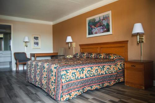 Habitación de hotel con cama y escritorio en America's Inn Houston/Stafford /Sugarland, en Houston
