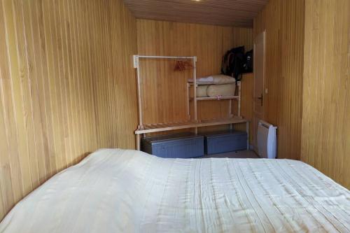 1 dormitorio con 1 cama y pared de madera en Appartement T3 en RDC 54 m2 avec balcon en Saint-Pierre-dels-Forcats