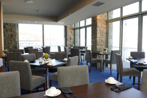 a restaurant with tables and chairs and windows at The Perisher Valley Hotel in Perisher Valley