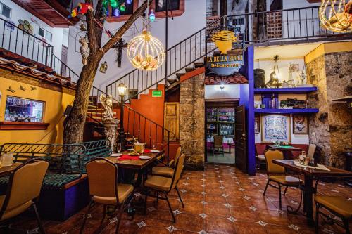 a restaurant with tables and chairs and a staircase at HOTEL BOUTIQUE EL VIEJO MUNDO in Hidalgo del Parral
