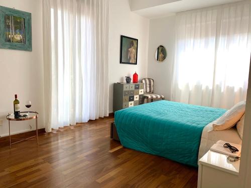 een slaapkamer met een bed met een blauwe sprei en een houten vloer bij Monkey in Reggio di Calabria