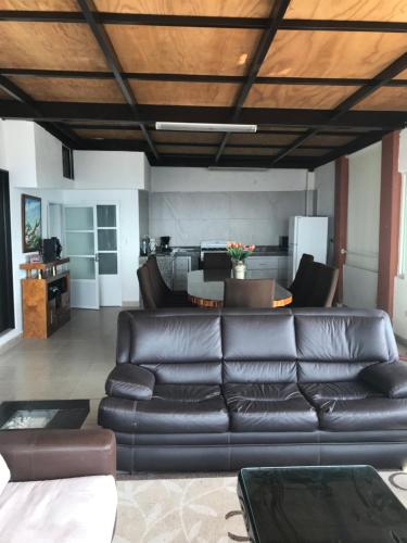 a living room with a leather couch and a table at Vista Taxco in Taxco de Alarcón