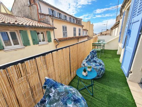 - un balcon avec deux chaises bleues et une table dans l'établissement GregBnb-com - Centre Ancien - Studio Roof-Top - CLIMATISÉ - 5eme étage, à Toulon