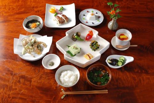 una mesa con platos de comida y tazones de comida en Katakuri no Yado, en Tsunan