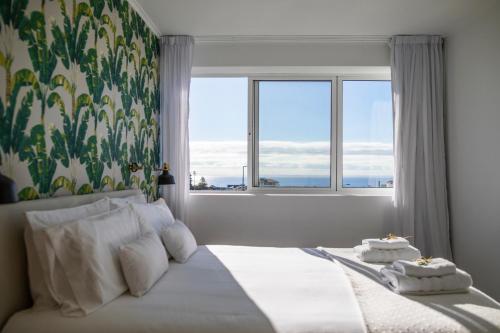 a bedroom with a bed with a large window at Toi et Moi Apartments-Guests speek for us! in Ponta Delgada