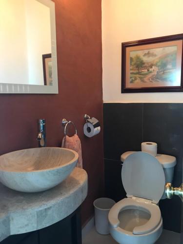 uma casa de banho com um lavatório e um WC. em Vista Taxco em Taxco de Alarcón