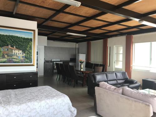 a bedroom with a bed and a couch and a table at Vista Taxco in Taxco de Alarcón