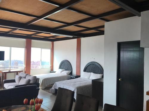 ein Hotelzimmer mit 2 Betten und einem Wohnzimmer in der Unterkunft Vista Taxco in Taxco de Alarcón