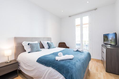 une chambre avec un grand lit avec des serviettes dessus dans l'établissement FEEL HOME - Congrès 13, à Nice