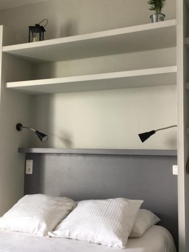 a bedroom with a bed with two lights above it at Le Cannier Hotel in La Seyne-sur-Mer