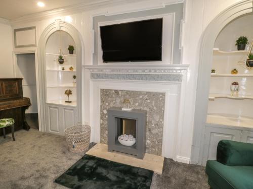 a living room with a fireplace with a flat screen tv at 47 Baxtergate in Whitby