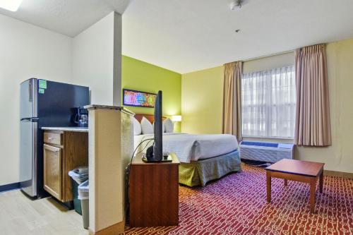 a hotel room with a bed and a flat screen tv at Extended Stay America Suites - Richmond - Glen Allen - Short Pump in Glen Allen