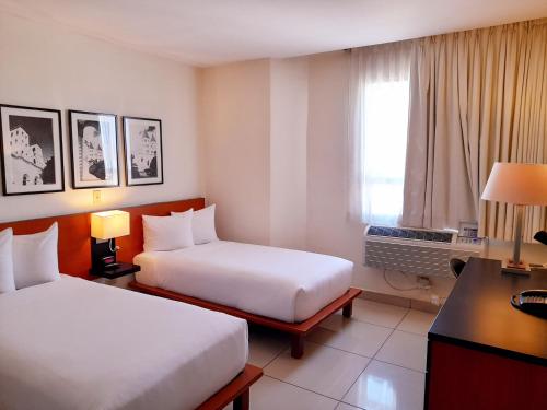 Un pat sau paturi într-o cameră la Comfort Inn Real San Miguel