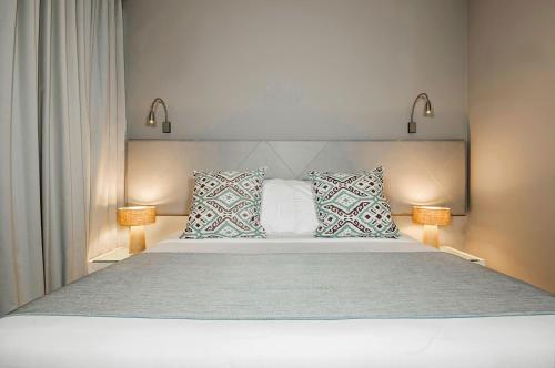 a bedroom with a large white bed with two lamps at Oz Hotel Cartagena in Cartagena de Indias