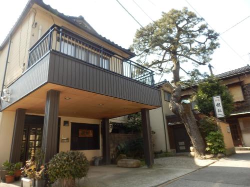 a building with a balcony on top of it at Minshuku Ginmatsu in Kanazawa