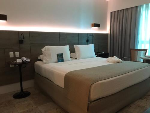 a bedroom with a large bed with white sheets and pillows at Hotel Atlante Plaza in Recife
