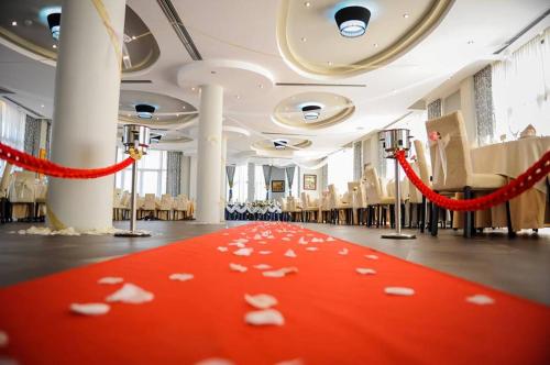 a room with a red carpet with white butterflies on it at Hotel Airport Tirana in Rinas