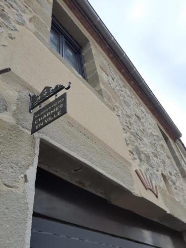 um edifício com uma placa sobre uma porta em CHARMES EN VILLE Le Charme Atypique em Montluçon