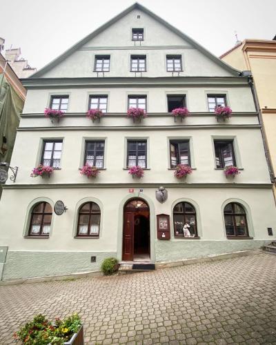 a large white building with flowers in the windows at Penzion U Fridy Apartman 1 in Loket