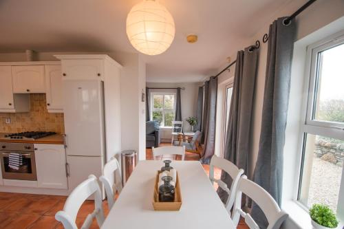 a kitchen and dining room with a table and chairs at Beautiful coastal house at the Drowes Rivermouth in Bundoran