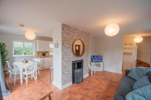 a living room with a table and a fireplace at Beautiful coastal house at the Drowes Rivermouth in Bundoran